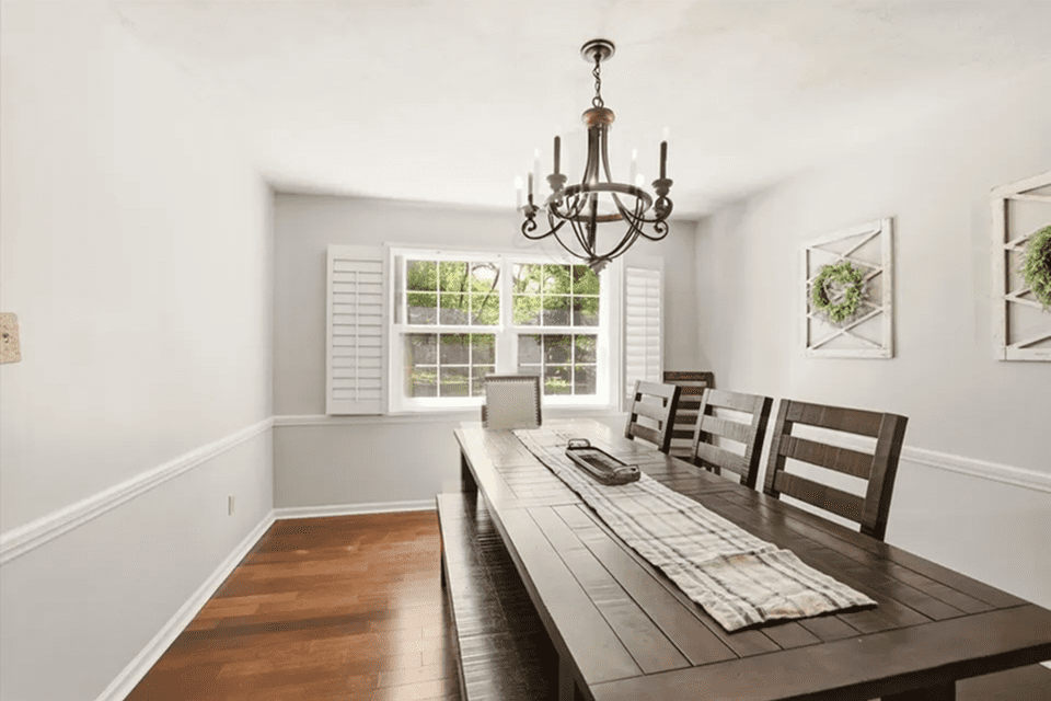 Dining room with wooden table and chandelier.
