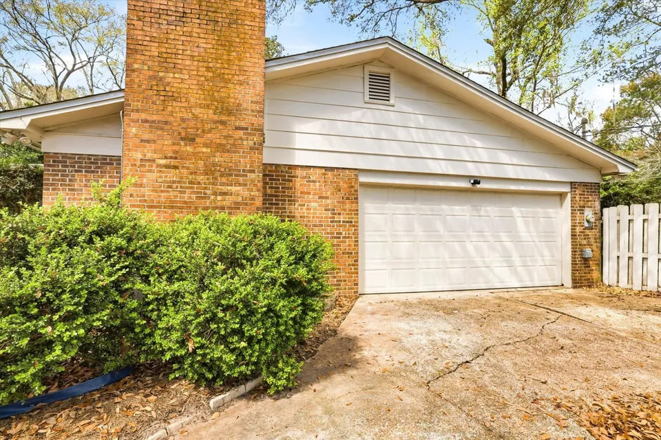Brick garage with white door and chimney.