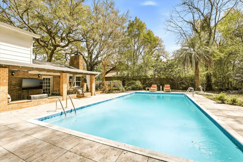 Backyard pool with patio and trees