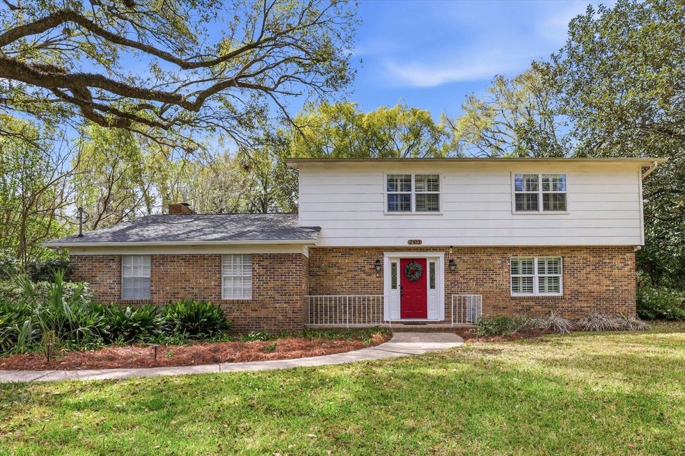 Two-story suburban house with a red front door and brick lower exterior.