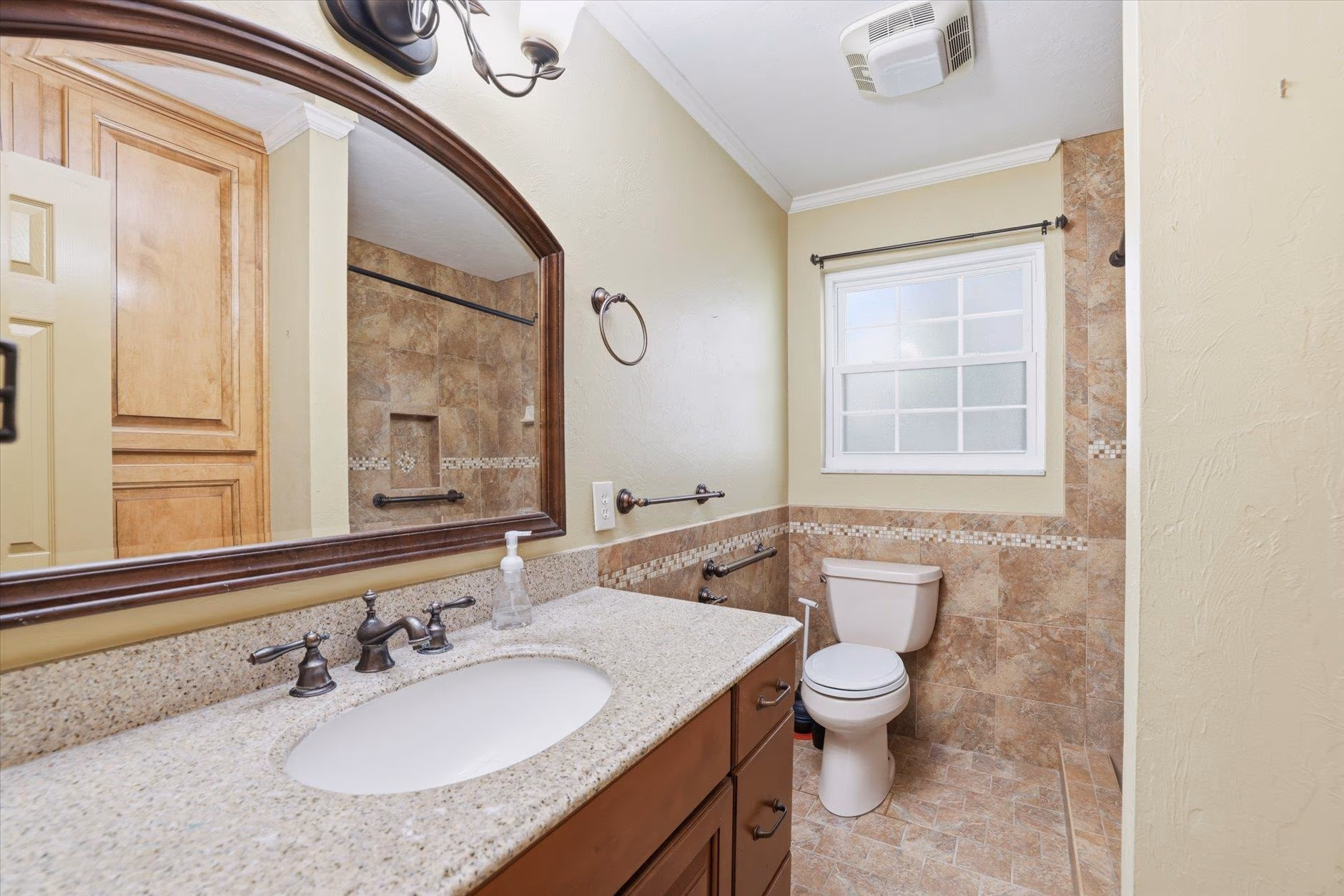 Elegant bathroom with wooden vanity and large mirror.