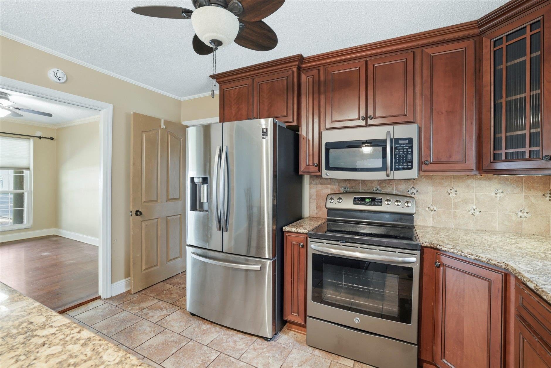 Modern kitchen with stainless steel appliances and wooden cabinets.