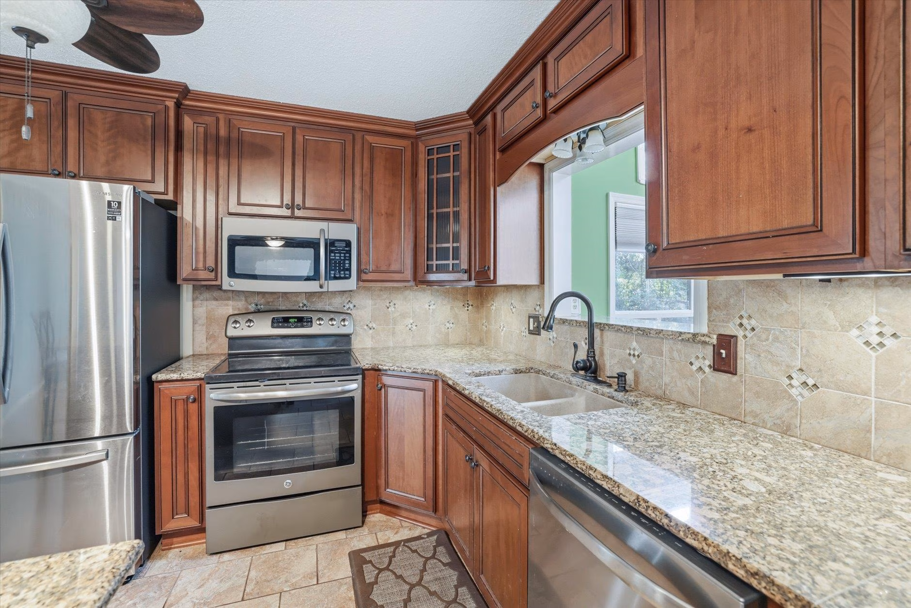 Modern kitchen with stainless steel appliances and wooden cabinets.