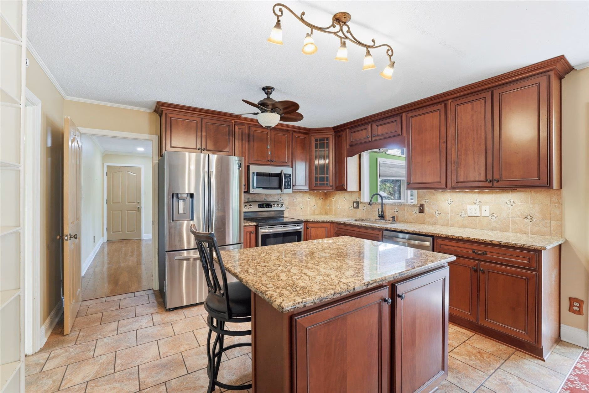 Spacious kitchen with granite island and stainless steel appliances.
