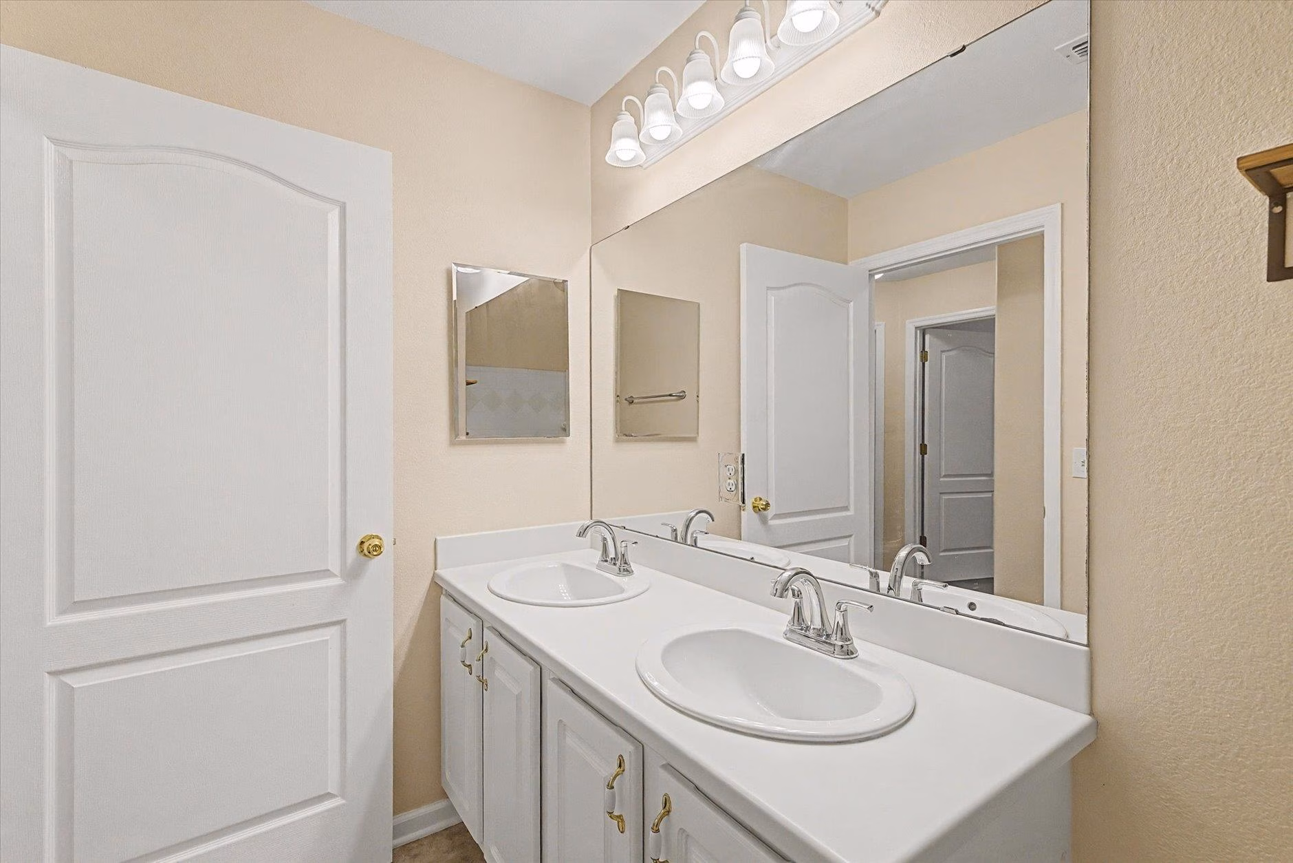 Clean bathroom vanity with double sinks and large mirror.